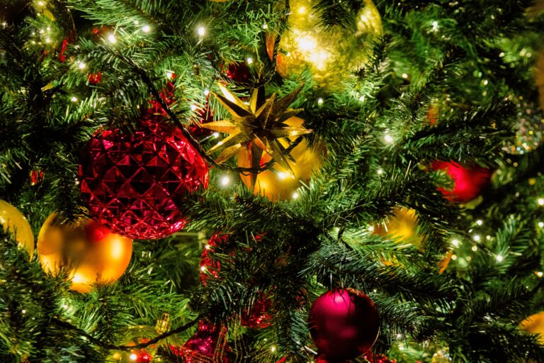 Captivating close-up of shimmering Christmas tree decorations and lights.