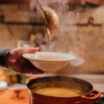 Steamy bowl of hot soup being served in a cozy kitchen setting.